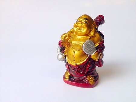 Statuette of Buddha laughing isolated on white .の素材