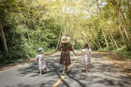 Mother and daughters walking in a parkの写真素材