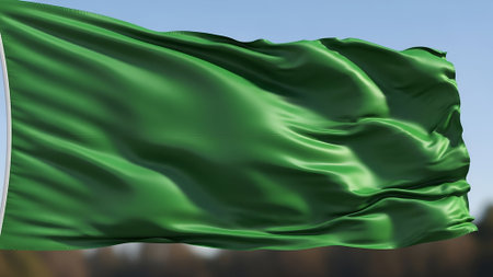 Green fabric flag waving in the breeze with bright natural lighting and flowing movement, creating an energetic and vibrant atmosphere suitable for outdoor or patriotic themes.の素材