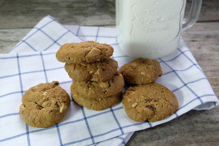 chocolate chip cookie and milk on wooden table.の写真素材