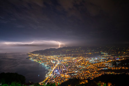 Lightning over the sea and the city at night. long exposureの写真素材