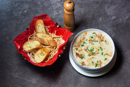 Cream of Mushroom Soup with garlic bread served in bowl isolated on grey background top view of...