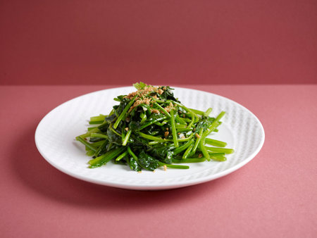 Stir-Fried Spinach with Garlic with chopsticks served in a dish isolated on mat side view on grey backgroundの写真素材