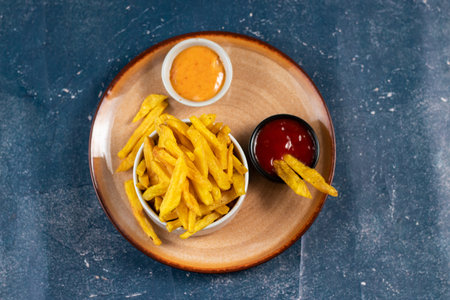 Crispy French Fries or potato chips with mayo dip and tomato sauce served in a plate side view view