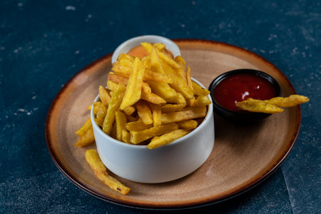 Crispy French Fries or potato chips with mayo dip and tomato sauce served in a plate side view viewの写真素材