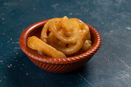 indian sweets deep fired jalebi, jilipi, jilabi served in a dish isolated on background top view