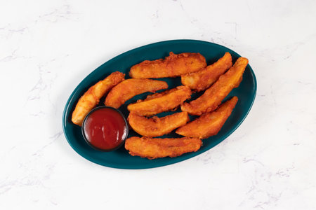 Potatos wedges with tomato sauce served in dish isolated on background side view of fastfoodの写真素材