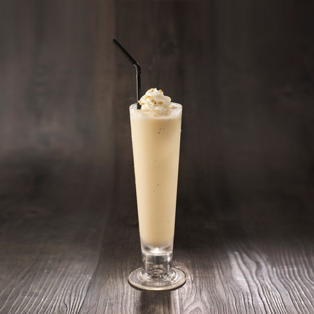 Vanilla Milkshake with straw served in glass isolated on table side view healthy morning drinkの写真素材