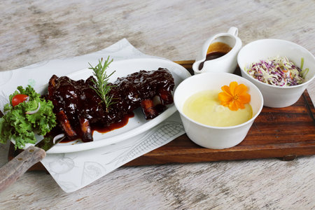 Full Slab BBQ Baby Back Ribs with sauce and salad served in a dish isolated on grey background side viewの写真素材