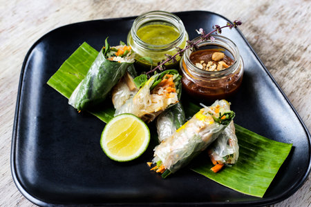 Fresh Spring Rolls with chilli sauce and lime served in a dish isolated on grey background side view of snacksの写真素材