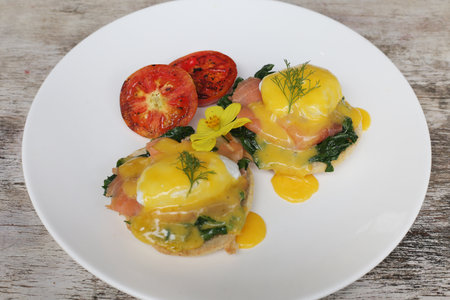 Eggs Benedict Smoked Salmon served in dish isolated on wooden background top view of breakfastの写真素材