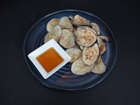 Eggplant Chips served in a dish isolated on dark background top viewの写真素材