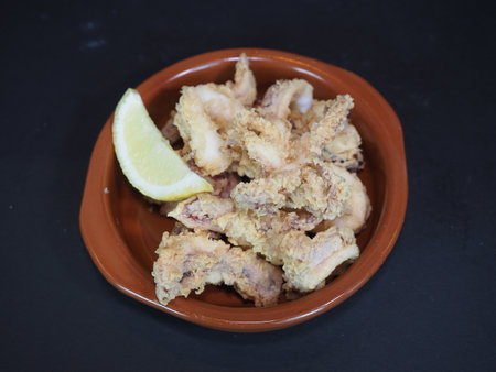Crispy Fried Squid served in a dish isolated on dark background top viewの写真素材