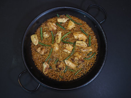 Traditional Paella served in a dish isolated on dark background top viewの写真素材