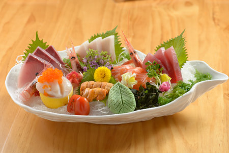 Fresh Japanese food mixed Sashimi Moriawase platter (raw seafood) with ice, fish slice a dish isolated on wooden background top viewの写真素材