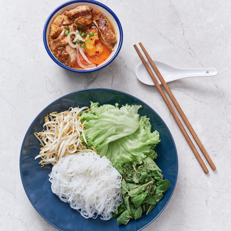 Chicken Bun Cha with noodle, roll and salad served in a dish isolated on grey background side view...