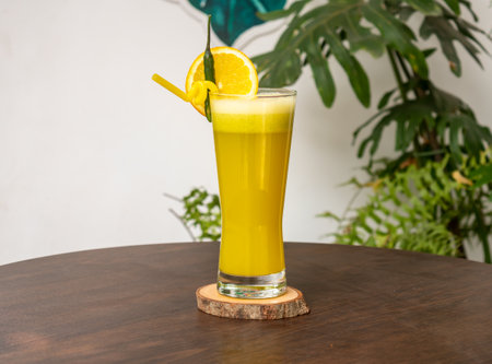 A glass of Orange juice with orange slice and straw isolated on wooden table side view healthy drink for vitamin cの写真素材