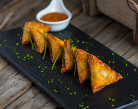 samboosa or samosa with ketchup served in a dish isolated on wooden background side view of...