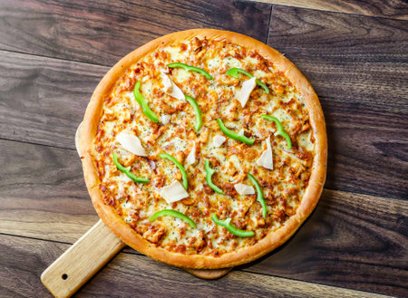 Chicken Fajita Pizza isolated on wooden background, spiced chicken cubes and cheese combination on bread, Italian food top viewの写真素材