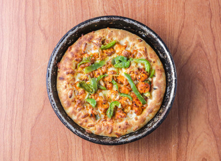 Chicken Fajita Pizza isolated on wooden background, spiced chicken cubes and cheese combination on bread, Italian food top viewの写真素材
