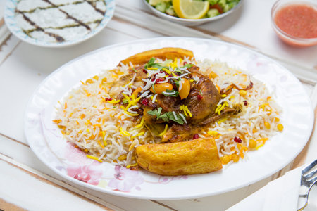 Fried rice with chicken and vegetables in white plate on wooden tableの写真素材