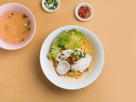 vietnamese food Sliced Fish Noodle in a bowl with soup, chili sauce and spring onion top view on wooden tableの写真素材