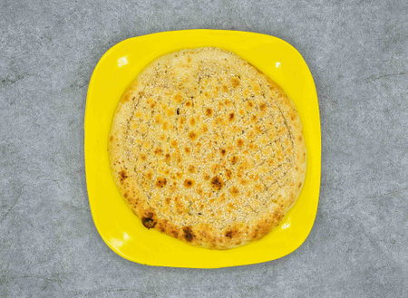 simple Naan in yellow plate top view on grey backgroundの写真素材