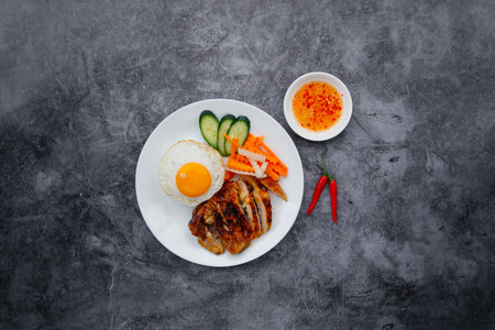 Grilled Chicken with egg, salad and chili sauce served in dish isolated on dark grey background top...