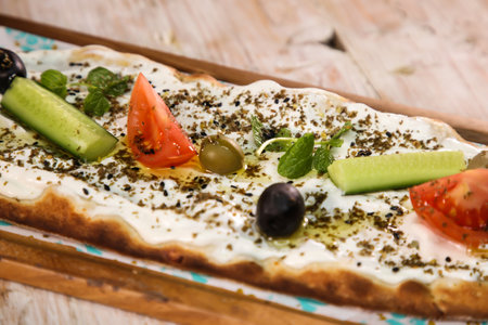 Labneh with zaatar pizza bread served in wooden board isolated on background top view of Arabic Manaqeeshの写真素材