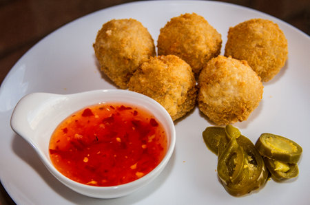 Deep fried JALAPENO BALLS with chilli sauce served in a dish isolated on table side viewの写真素材