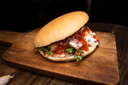 Pita Pocket Sandwich filled with tomato, onion, chicken, mayo and ketchup isolated on wooden board top view of arabic fastfoodの写真素材