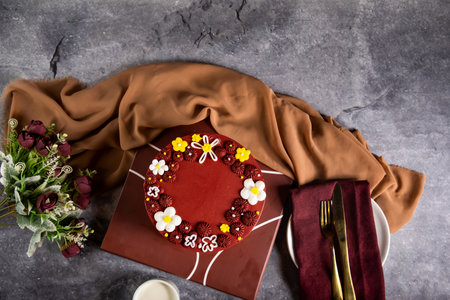 Chocolate Golden Lace Cake with rose flowers, knife and fork served on board isolated on napkin top view of cafe baked foodの写真素材