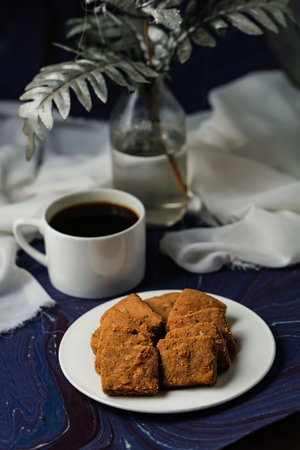 Crunchy cookies biscuits served in plate with black coffee isolated on table side view of american...