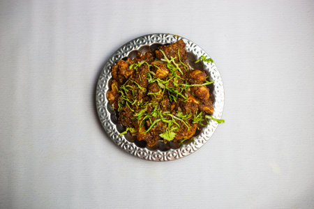 Spicy Chicken masala chaap with coriander served in plate isolated on background top view of...