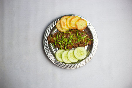 Spicy Beef chaap with tomato and cucumber served in plate isolated on background top view of bangladeshi, indian and pakistani traditional spicy foodの写真素材