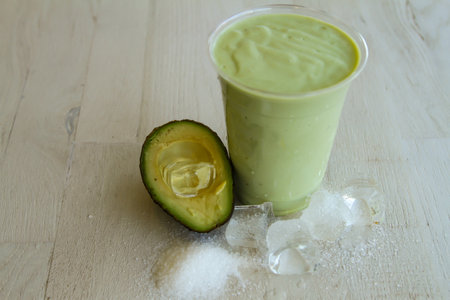 Fresh avocado juice served in disposable glass isolated on table side view of healthy morning juice drinkの写真素材