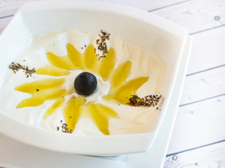 Labna Dip with Olive Oil served in dish isolated on wooden table top view of cold mazza arabic foodの写真素材