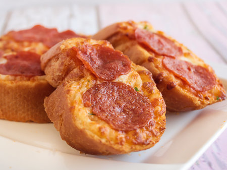GARLIC BREAD TOPPED WITH CHEESE AND PEPPERONI served in dish isolated wooden table top view arabic food appetizerの写真素材