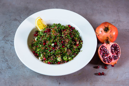 Quinoa Salad with pomegranate seeds and lime slice served in dish isolated on grey background top view of bahrain foodの写真素材