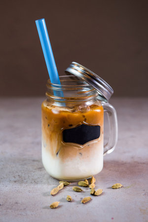 Iqaily Latte or Icarly coffee serving in jar with straw side view on background