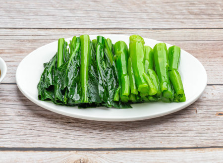 seasonal vegetables with oyster sauce served in dish isolated on wooden table top view hong kong foodの写真素材