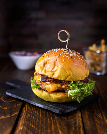 Grill Chicken Burger with melted cheese and lettuce leaves served in dish isolated on wooden table side viewの写真素材
