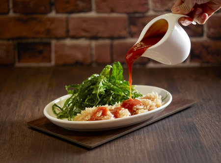 Crispy Kang Kong topped with Cuttlefish in Homemade Seafood Sauce served in a dish isolated on mat side view on dark backgroundの写真素材