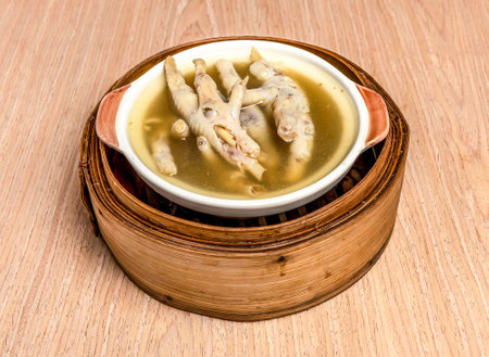 Medicinal Chicken Feet Soup served in bamboo steamer isolated on wooden table side view of hong kong foodの写真素材