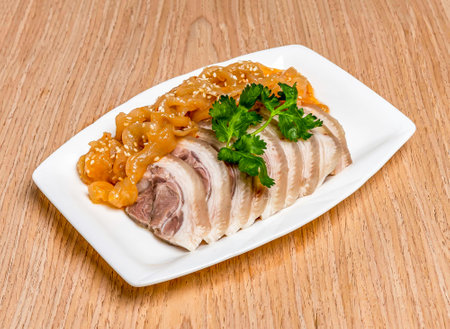 Jellyfish and chilled sliced Pork trotter topped with sesame seeds and coriander served in tray dish isolated on wooden table side view of hong kong foodの写真素材
