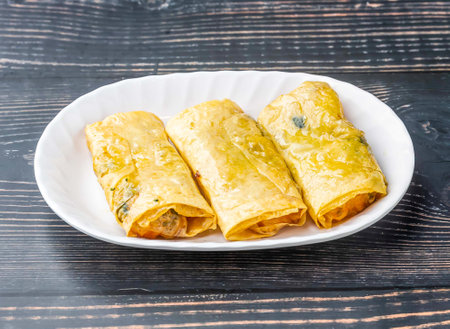 Shrimp and Bean Curd Rolls served in tray dish isolated on wooden table side view of hong kong food