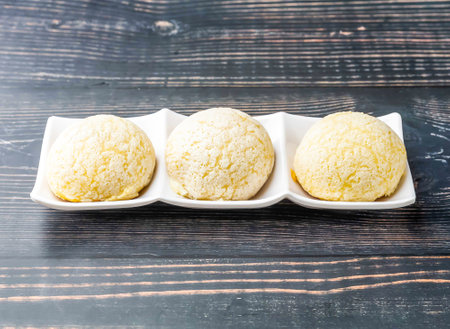 Chinese Barbecued Pork Buns served in tray dish isolated on wooden table side view of hong kong food