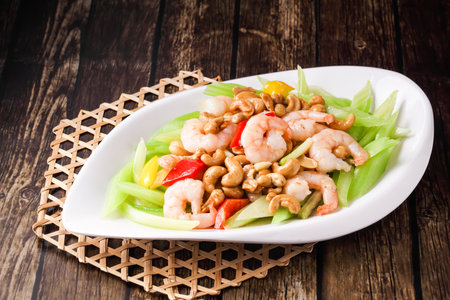 Shrimp with Celery and Cashew Nuts served in dish isolated on wooden background side view of hong kong foodの写真素材