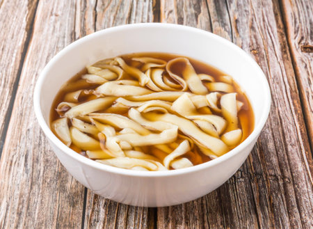 Sliced âânoodles soup served in bowl isolated on wooden table side view of hong kong foodの写真素材