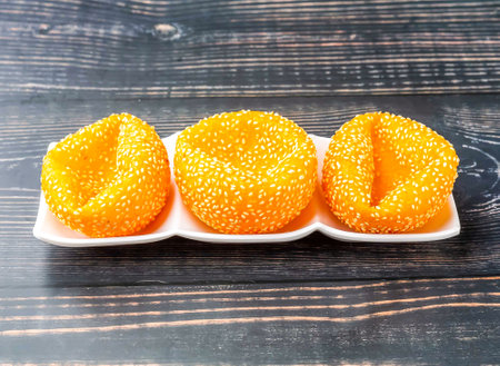 Fried Dumplings with sesame seeds served in tray dish isolated on wooden table side view of hong...